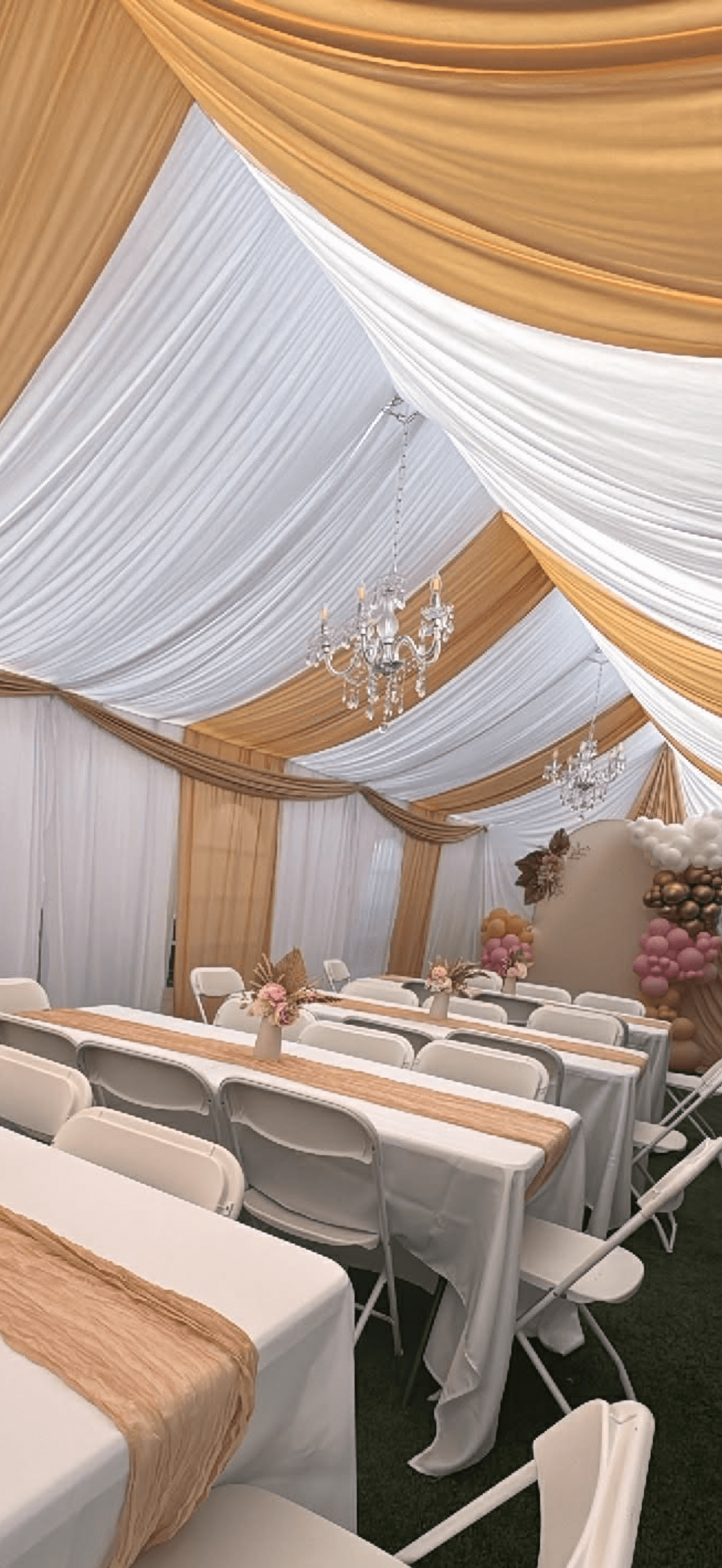 Tent interior with gold draping and chandeliers